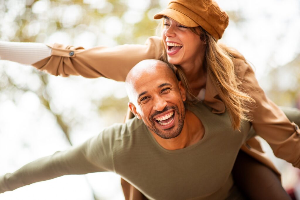 Pärchen lachend in der Natur: Sie freuen sich, dass sie den Vitamin B12-Mangel mit hochdosiertem Vitamin B12 ausgleichen konnten.